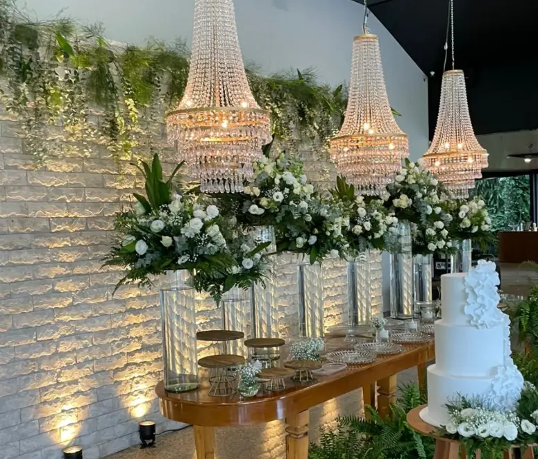 Recepção com mesas BJ, lustres de cristal e arranjos florais